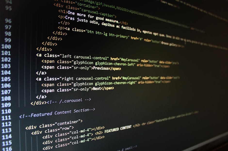 A close-up photograph of a computer screen displaying lines of HTML code in various colors, including yellow, blue, red, and white. The code features tags such as <h1>, <div>, <img>, and classes like 